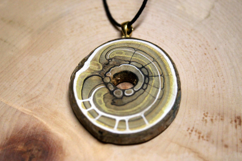 Nahaufnahme des Amulettes aus Essigbaum mit Loch